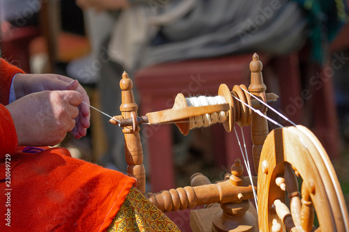 Making yarn with old-fashioned spinning wheel