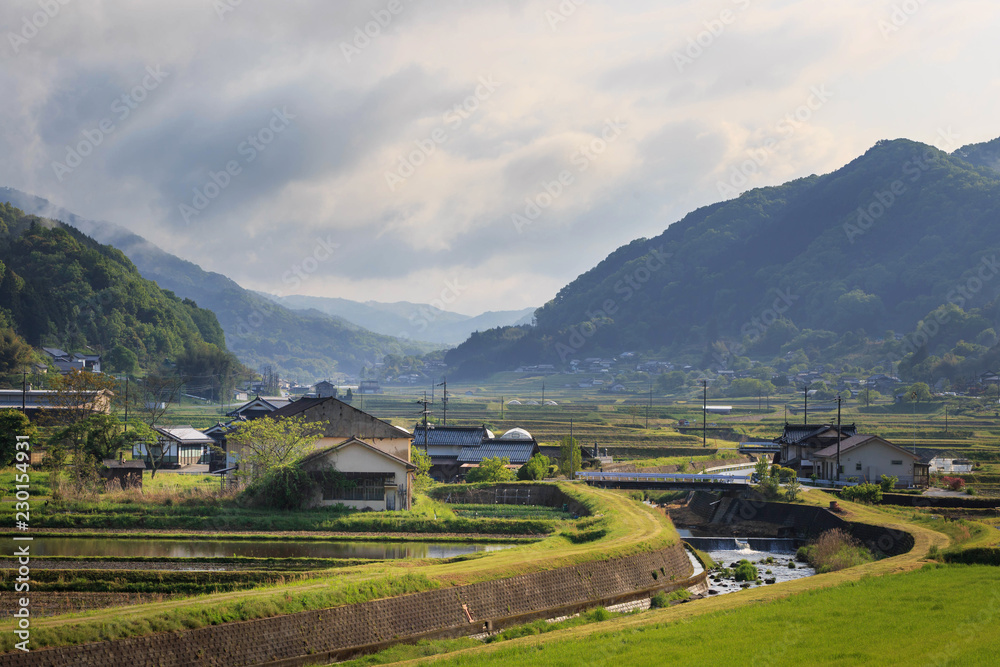 River curves through small farming town in rural Japanese mountains