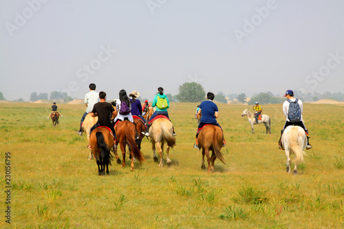 Travelers on horseback in the WuLanBuTong grassland, China