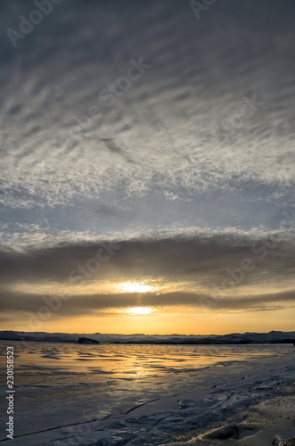 Frozen Lake Baikal. Beautiful stratus clouds over the ice surface on a frosty day.