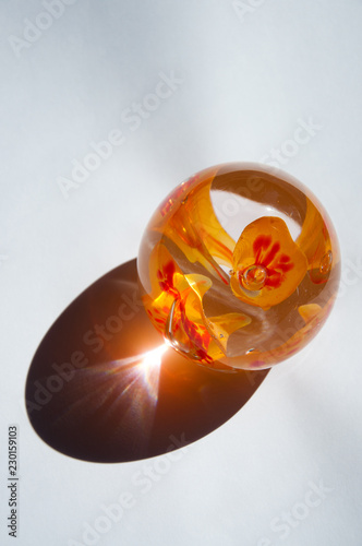 фотографія Orange glass paper weight made from broken shards