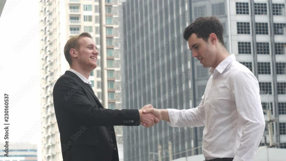 Closeup of two business people hands giving fist bump,Businessmen Shaking Hands on Business Deal on city background. Closeup of two business people hands giving fist bump,Businessmen Shaking Hands on Business Deal on city background.