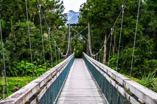 Fototapeta Naklejka Na Ścianę i Meble -  The wooden swing bridge in the green nature.