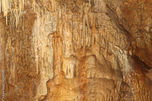 wonderful natural cave with fox-colored walls and formations of stalactites within, natural texture photo. © Dancing Man
