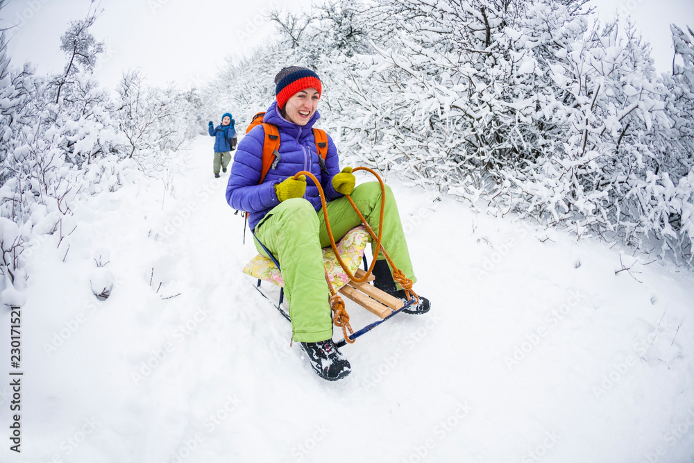 Mom is riding a children's sled.