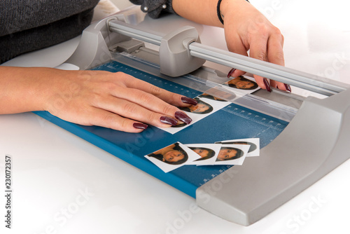 Woman cutting and sizing passport photos photo