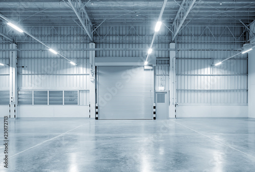 Roller door or roller shutter inside factory, warehouse or industrial building. Modern interior design with polished concrete floor and empty space for product display or industry background. photo