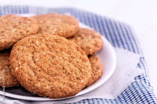 Homemade shortbread cookies made of oatmeal are stacked in plate on cloth on white table background. Food snack for enjoy in holiday concept. with copy space for text.