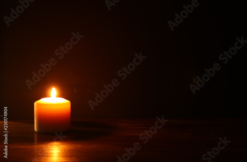 Burning candles over black background.