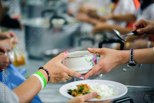 Sharing of food from volunteer hands to homeless people : The concept of feeding © kuarmungadd