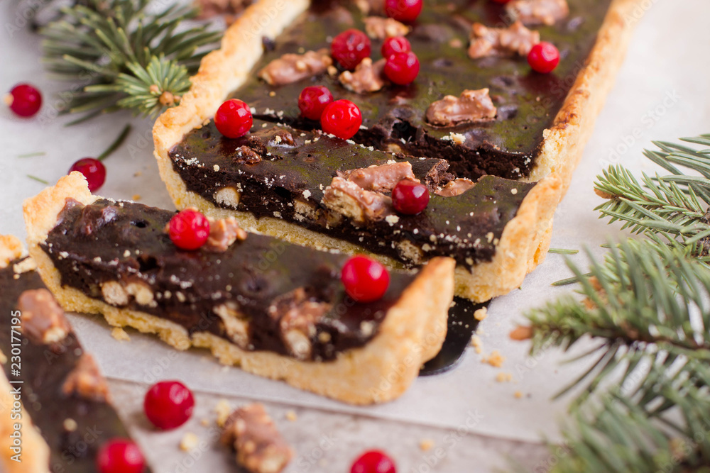 Chocolate tart with cranberries for Christmas holiday on gray table background. Chocolate tart with cranberries for Christmas holiday on gray table background.