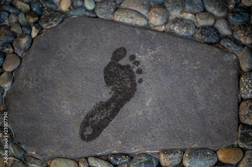 footprints of bare feet on a gray stone. wet footprints photo