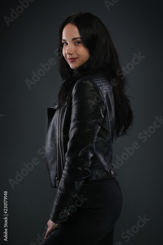 Girl in black leather jacket on gray background