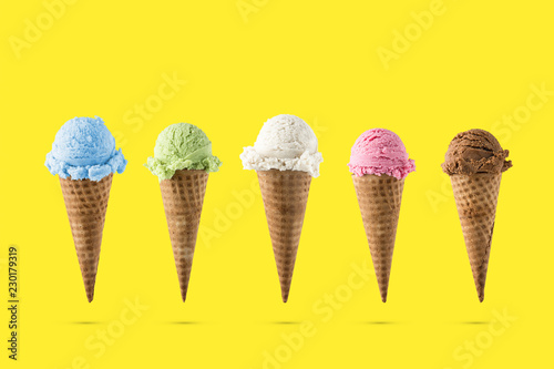 Variety of ice cream flavor in cones blueberry ,strawberry, green tea, chocolate and coconut setup on yellow background . Summer and Sweet menu concept.