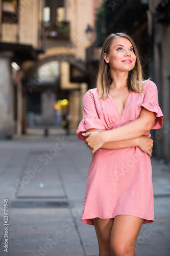 Young positive female standing in the historical center of Barcelona