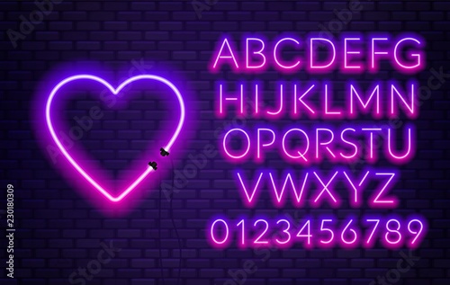 Neon alphabet with heart on brick wall background.
