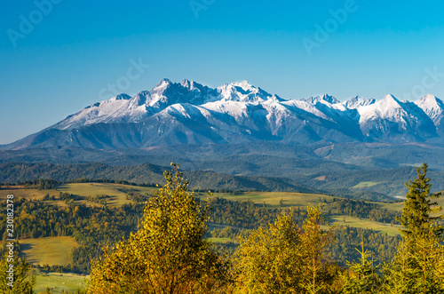 Fototapeta Naklejka Na Ścianę i Meble -  Morning panorama of snowy Tatra Mountains over colorful autumn forest, Poland