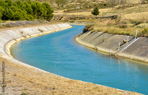 CANAL OF WATER IN A WALL OF CONCRETE IN THE SURFACE OF THE FIELD