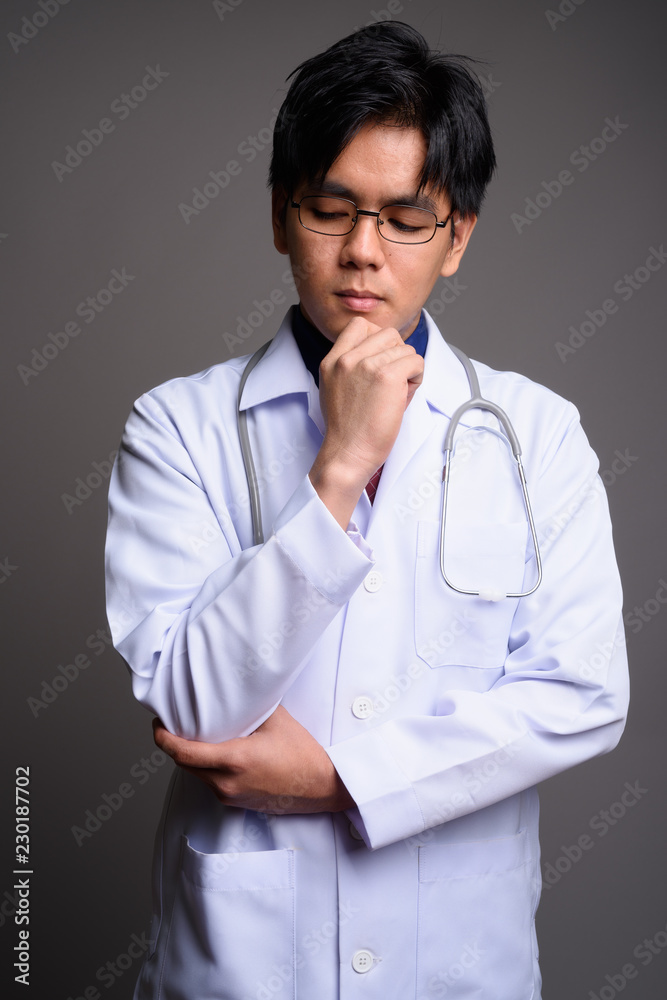 Portrait of young serious Asian man doctor thinking Portrait of young serious Asian man doctor thinking