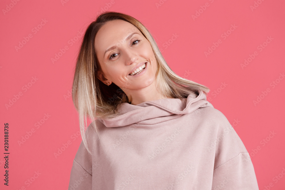 Сheerful young blond woman posing in pink pullover Сheerful young blond woman posing in pink pullover