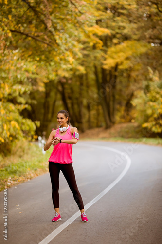 Young woman have a break during training in the autumn forest