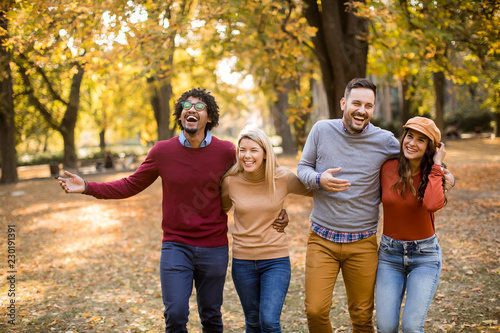 Multiracial young people walking in the autumn park