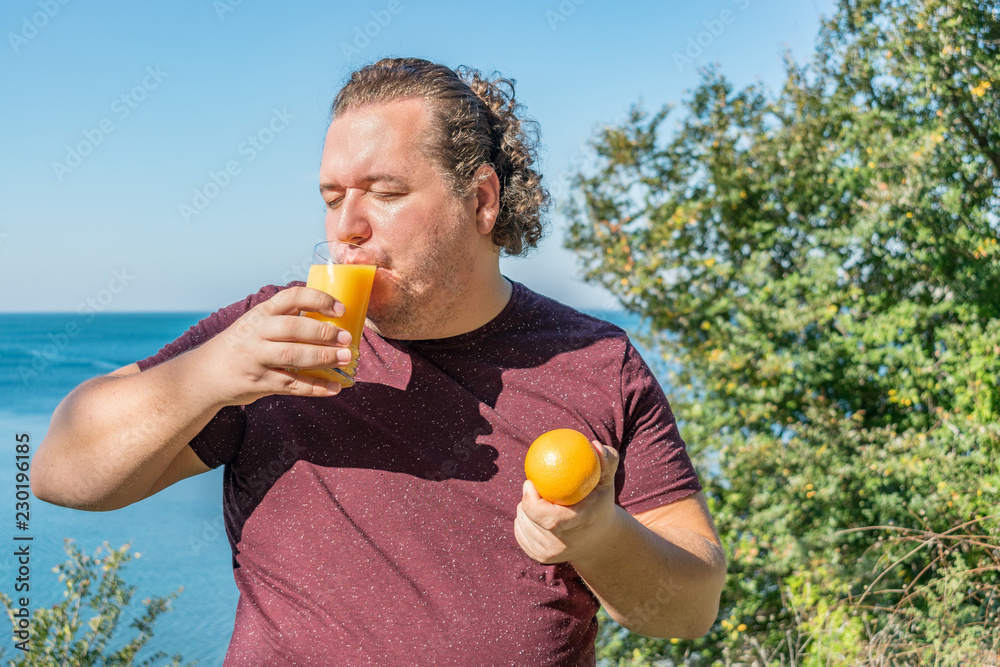 Funny fat man on the ocean drinking juice and eating fruits. Vacation,  weight loss and healthy eating Stock Photo | Adobe Stock