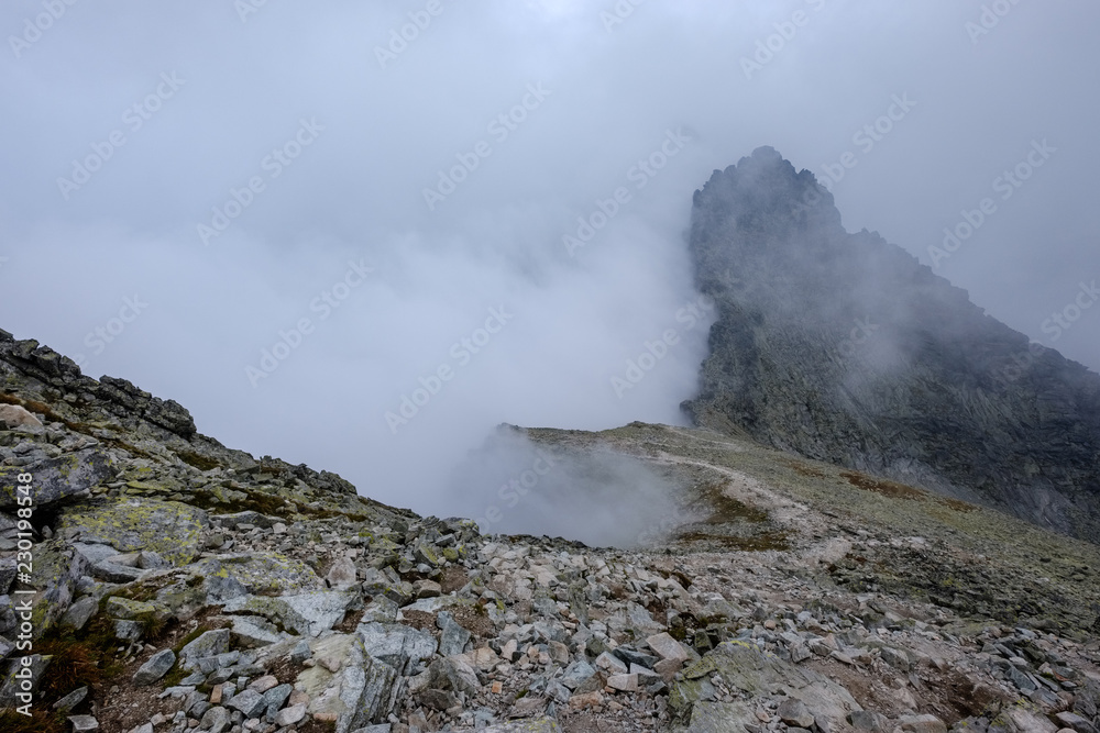 Fototapeta premium peak of Rysy mountain covered in mist. autumn ascent on hiking trails