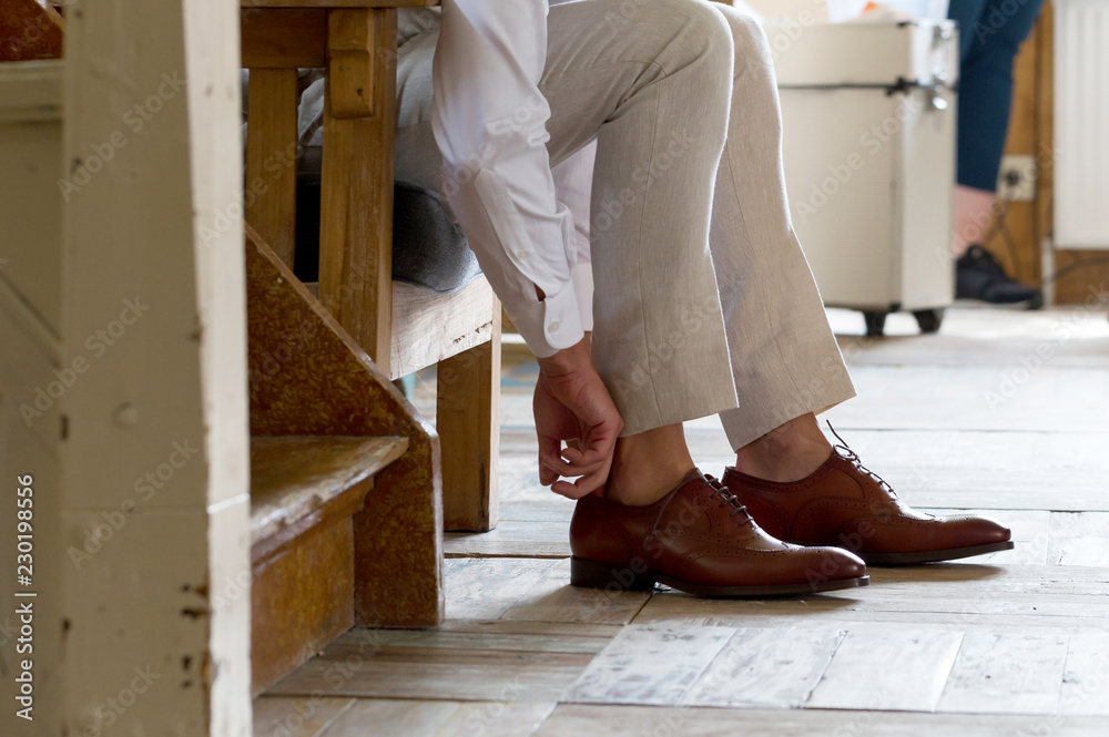 Man in a business suit ties the laces Man in a business suit ties the laces