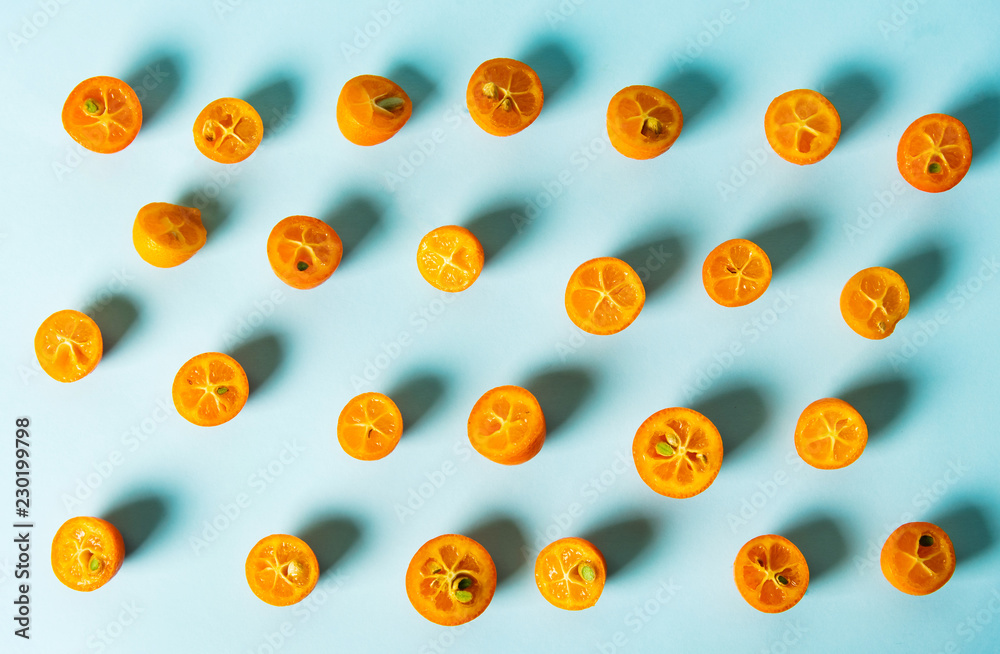Kumquat fruit slices on blue background
