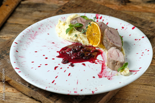 Baked rabbit meat roll with white mashed potato and cherry sauce