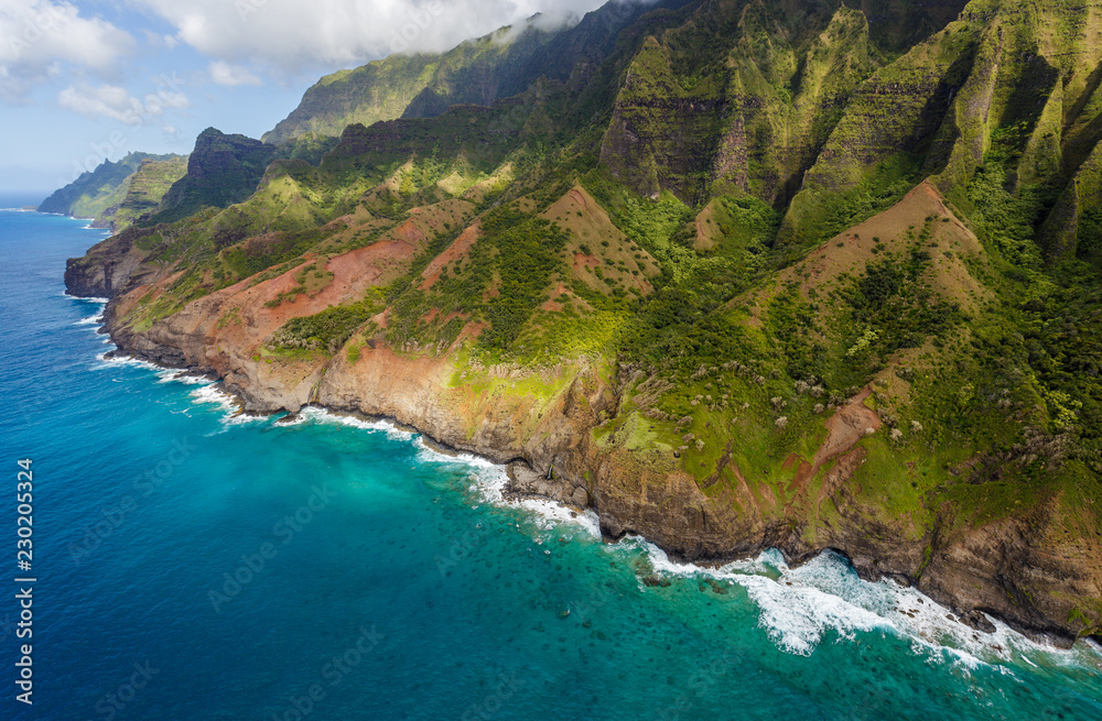 Fototapeta premium View of the monumental Na Pali Coast at Kaa Alahina Ridge and Manono Ridge, Kalalau trail visible if zoomed in. Aerial shot from a helicopter, Kauai, Hawaii.