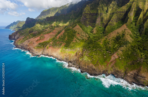 View of the monumental Na Pali Coast at Kaa Alahina Ridge and Manono Ridge, Kalalau trail visible if zoomed in. Aerial shot from a helicopter, Kauai, Hawaii. photo