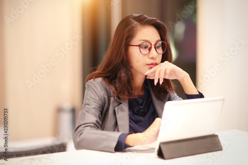 working and charming woman with glasses using tablet (work from home concept)