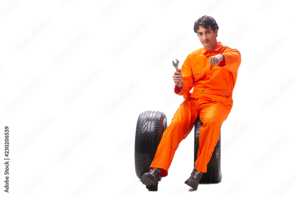 Young garage worker with tyre isolated on white Young garage worker with tyre isolated on white