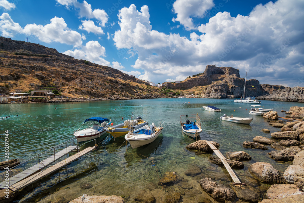 St. Paul bay with boats, Lindos acropolis in background (Rhodes, Greece).