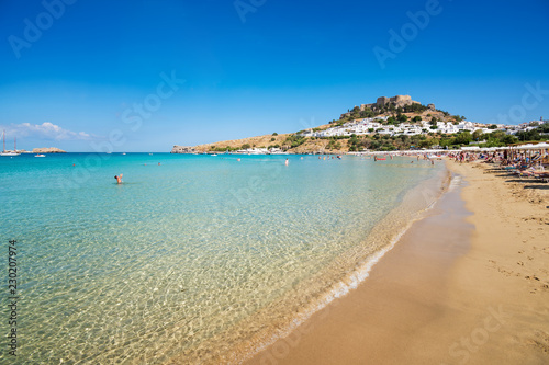 View of sandy beach in Bay of Lindos  Acropolis in background  Rhodes  Greece .