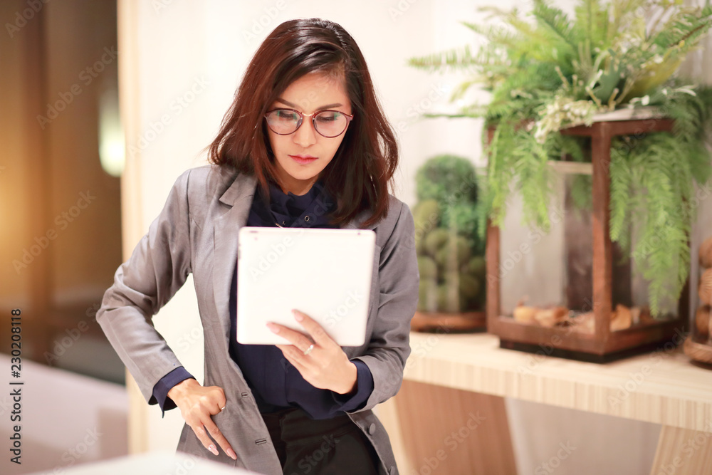 beautiful businesswoman portrait with glasses using tablet (this image for business and technology background concept) beautiful businesswoman portrait with glasses using tablet (this image for business and technology background concept)
