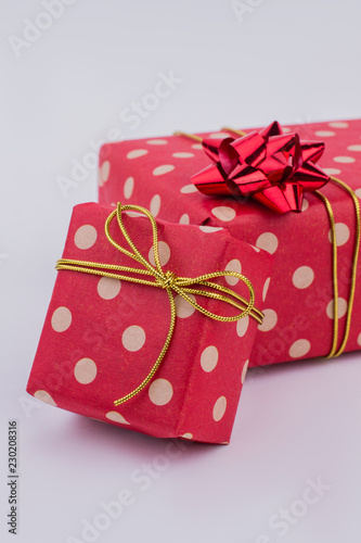 Gift boxes wrapped in fashion design paper. Present boxes in red dotted paper with bow. Christmas holiday atmosphere. © DenisProduction.com