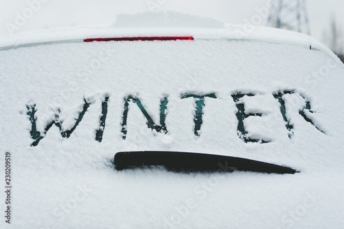 Closeup of snow covered car with word 