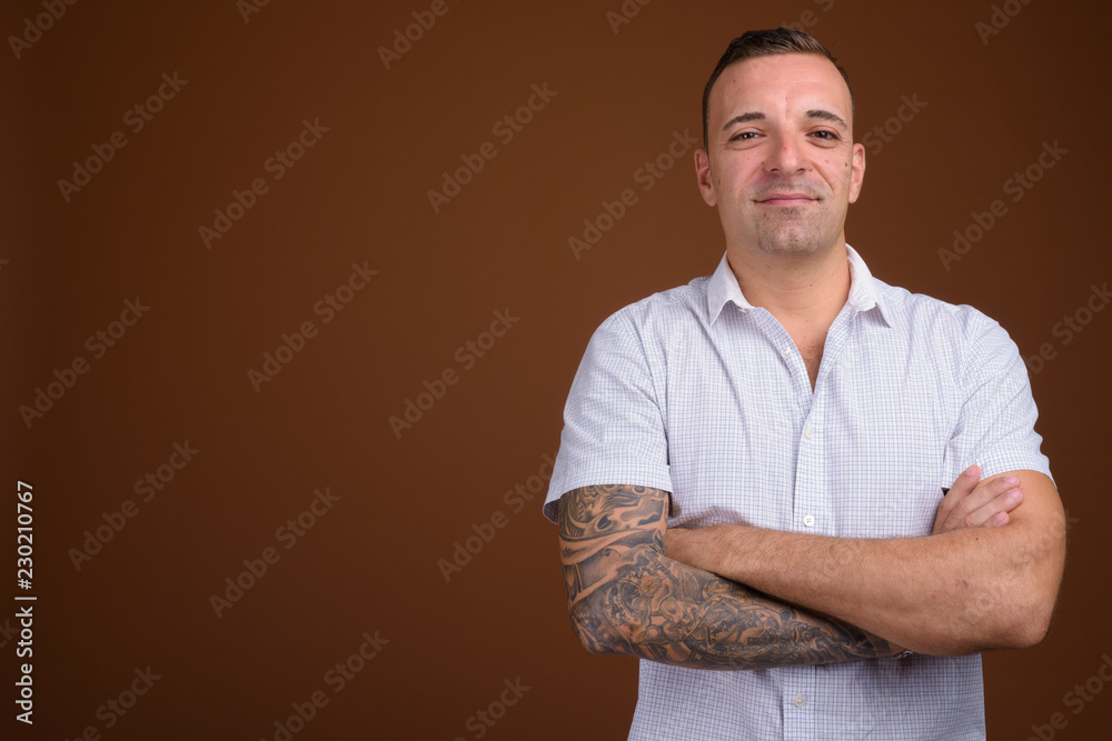 Man wearing white shirt against brown background Man wearing white shirt against brown background