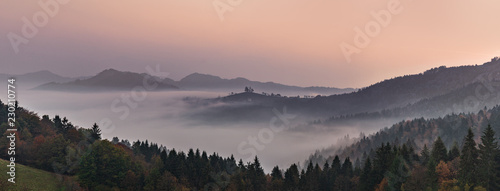 Panoramic foggy landscape at dawn over mountain and valley