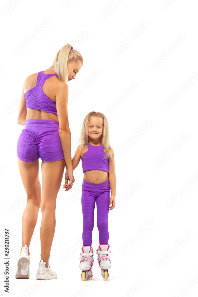 Family, mother and daughter, posing in studio wearing inline rollerskates Family, mother and daughter, posing in studio wearing inline rollerskates