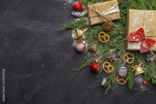 Christmas composition of coniferous branches, decorations and sweets on dark background. Flat lay. Top view Nature New Year concept. Copy space.