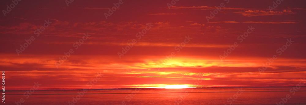 Flaming sunset in sea, bay at sunrise.