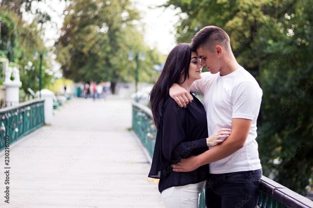 Young couple, a guy with a girl hugging in the park.
