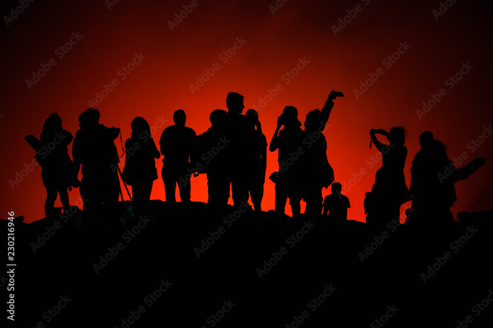 Photo of unrecognized tourists' silhouettes on Erta Ale Volcano edge illuminated with lava. Danakil Depression, Ethiopia, East Africa