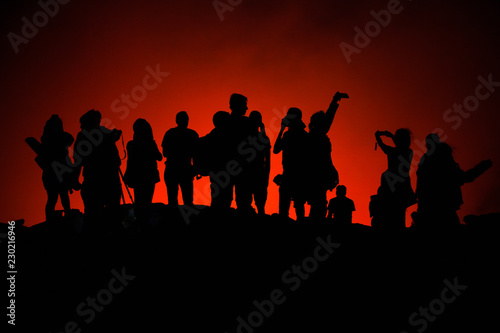 Photo of unrecognized tourists' silhouettes on Erta Ale Volcano edge illuminated with lava. Danakil Depression, Ethiopia, East Africa
