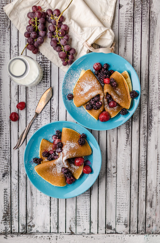Homemade crepes with frozen berries, topped sugar