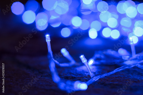 soft focus night winter holidays decoration with blue garland illumination sparkles and bokeh effect, copy space